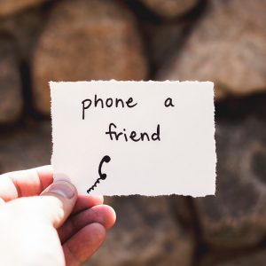 hand holding paper that reads phone a friend