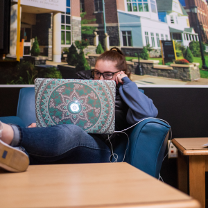 female student with a laptop and headphones
